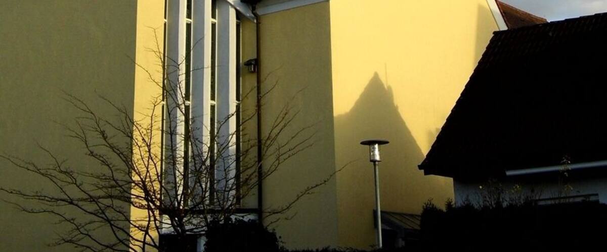 A church with a green spire and a clock.