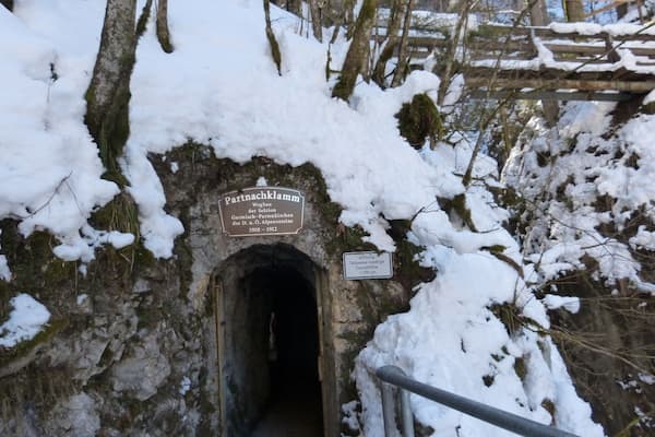 A snow-covered tunnel entrance with a sign indicating it was built between 1910 and 1912.