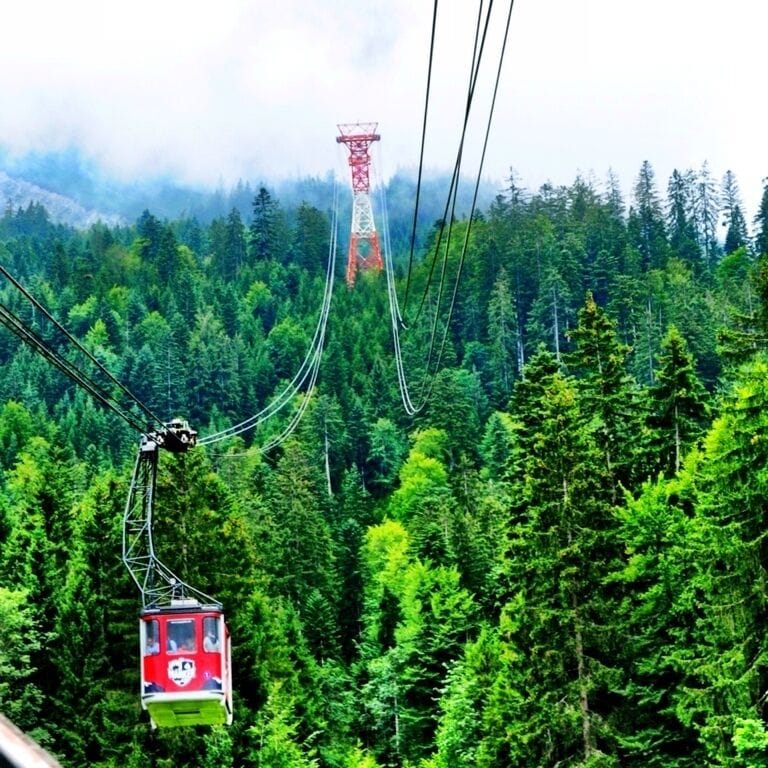 Travel by cable car to the summit of Zugspitze, Germany's highest mountain on the border to Austria. The Eibsee Cable Car opened in 1963 and connects the lower station, 3,192 feet above sea level, with the top station at 9,678 feet above sea level. 

The Eibsee Cable Car belongs to Bayerische Zugspitzbahn Bergbahn AG, the company operating the cog railway and most cable cars, gondola lifts, and chairlifts in the Garmisch-Partenkirchen area. This means you can make round trips using both the cog railway and the cable car. 

The Eibsee Cable Car runs over two pylons, which are about 213 ft and 279 ft high. Two cabins take 44 people each and are suspended from two track ropes and moved by two haulage ropes. The tramway can accommodate 300 giggling picture snapping tourists per direction each hour. The elevation gain of 6,398 ft is the highest of all aerial cableways achieved in a single section. German engineering rocks !

NOTICE  - If you have a thing about heights AND your claustrophobic ...... Think hard before subjecting the rest of us to your over-dramatic panic attack. As amusing as it might be at first.... it gets old after the 4000 foot mark and we are likely to vote you off the cable car around 6000 feet!
