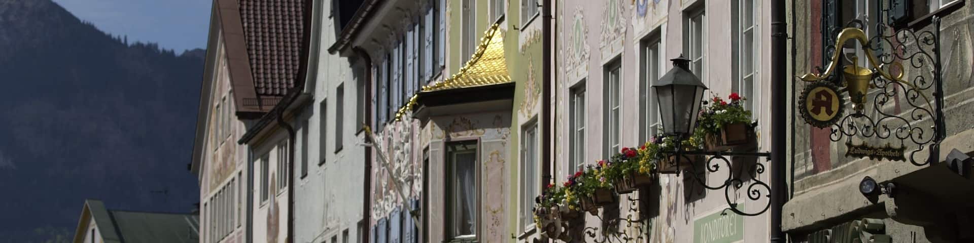 A street with traditional European architecture, including ornate facades and flower baskets.