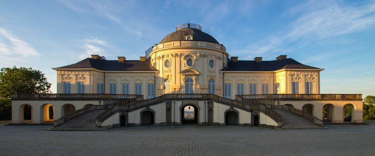 A large, historic building with a dome and a grand staircase leading to the entrance.