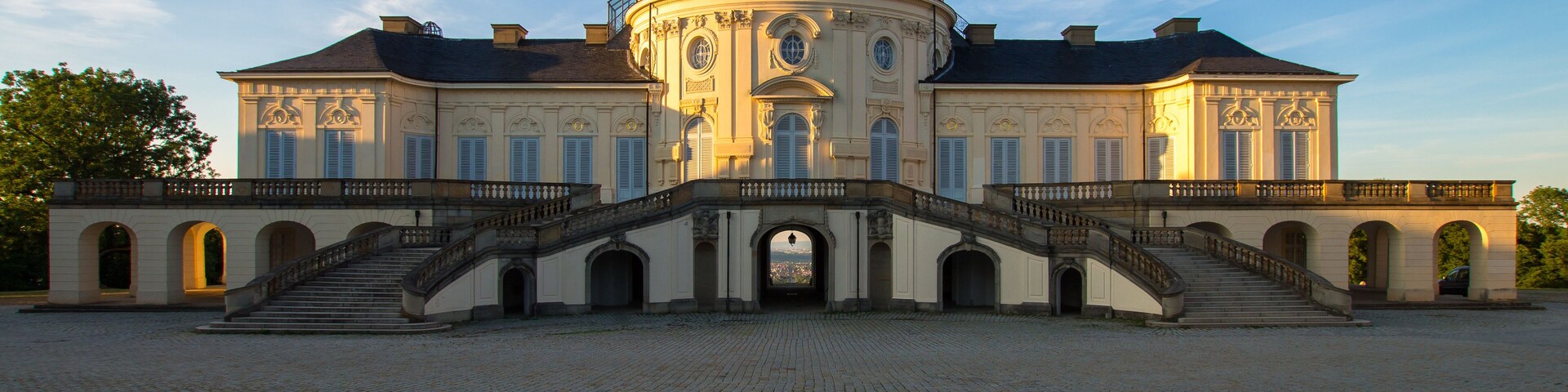 A large, historic building with a dome and a grand staircase leading to the entrance.