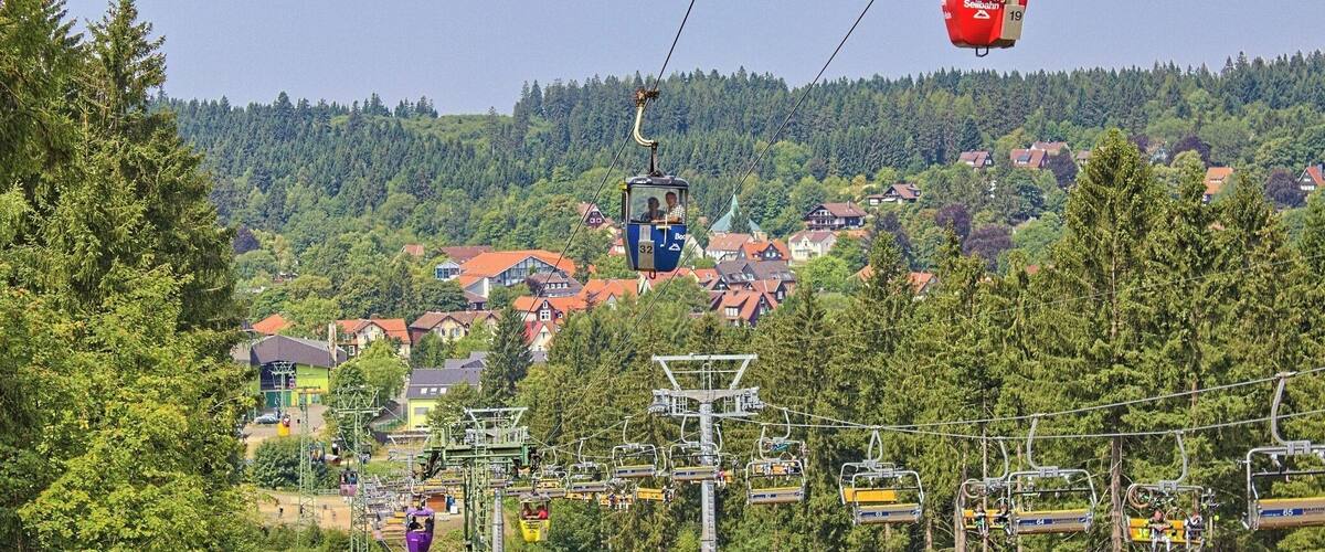 A cable car system with houses and trees in the background.