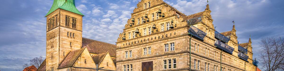 A historic building with a prominent green spire and detailed architecture.