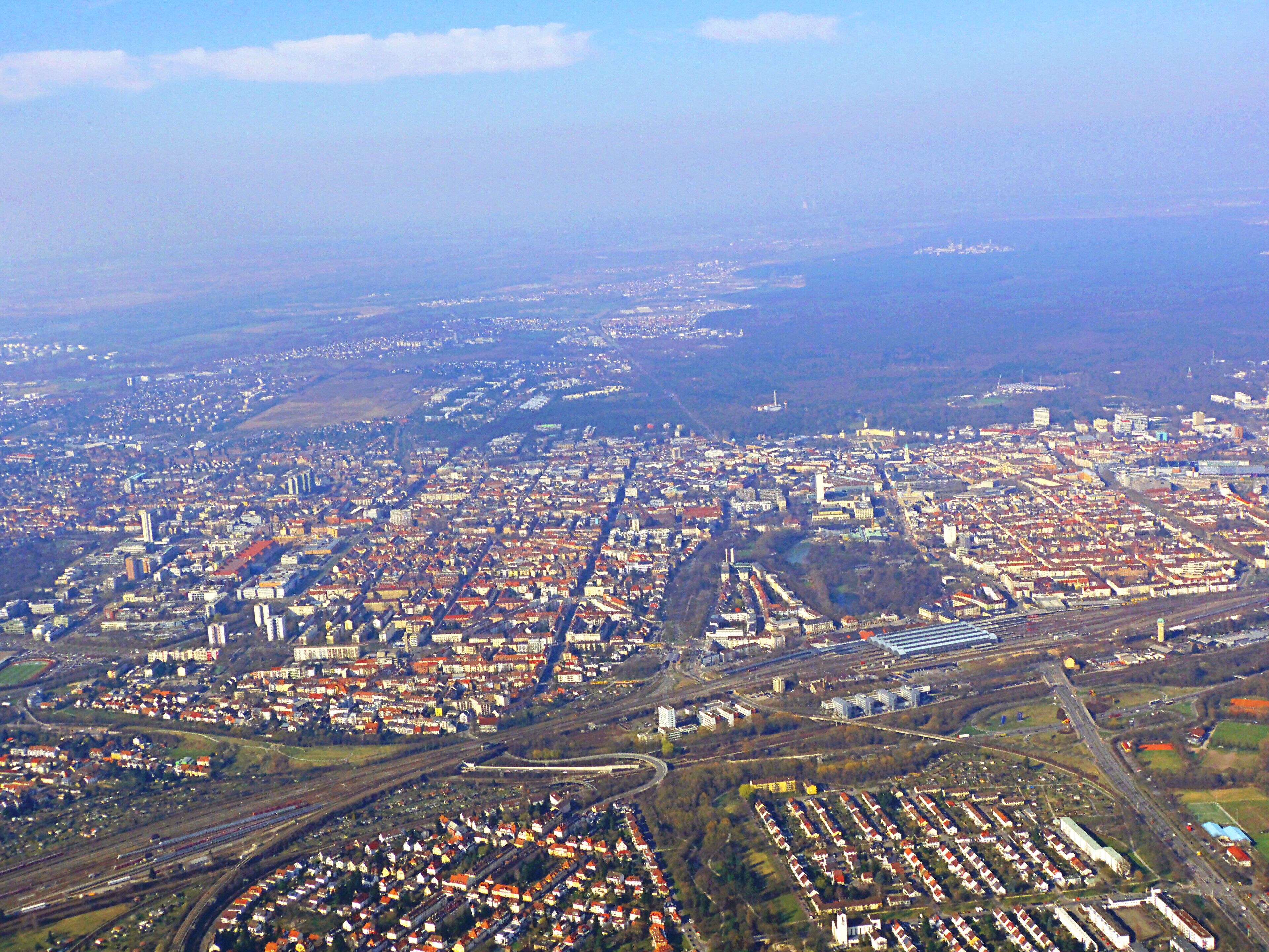 An aerial view of a densely populated city with extensive railway infrastructure and residential areas.