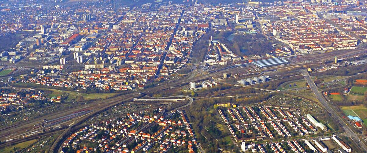 An aerial view of a densely populated city with extensive railway infrastructure and residential areas.