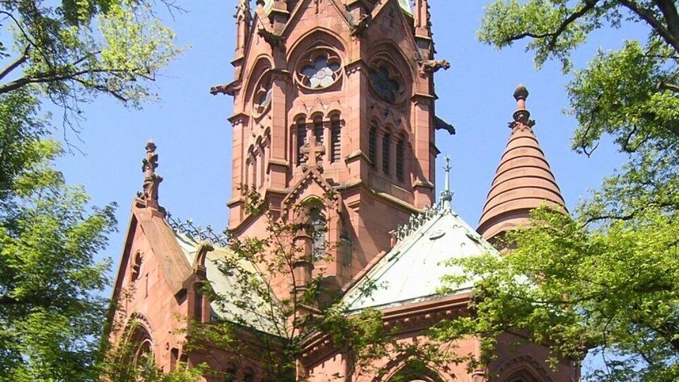 A large, ornate church with a tall spire and intricate architectural details.