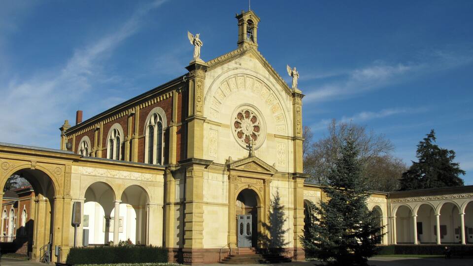 A historic building with arched windows and statues on the roof.