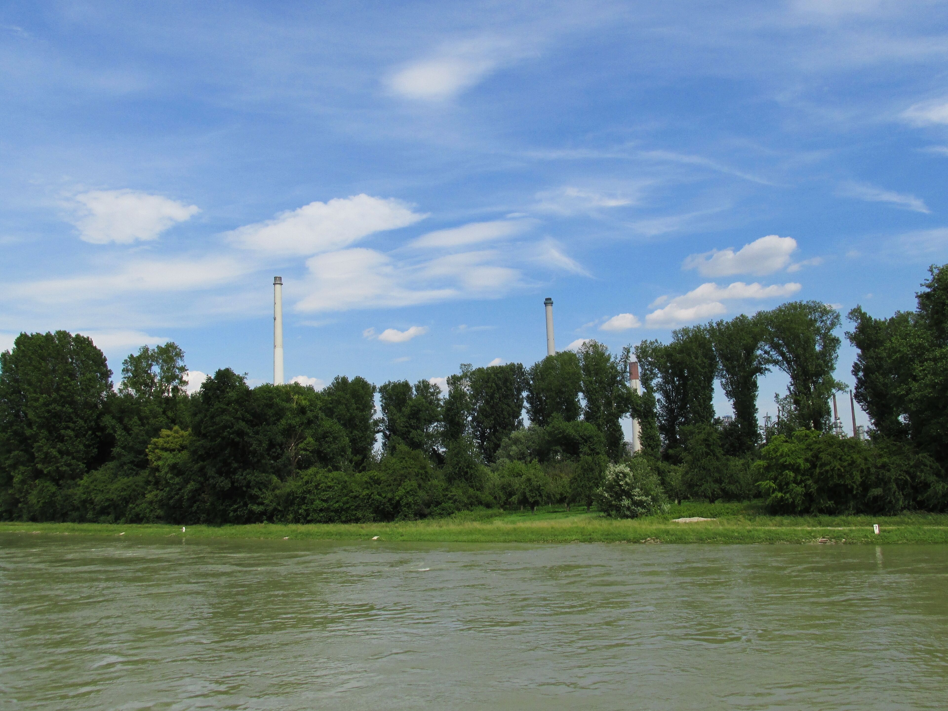 A river with industrial chimneys in the background.