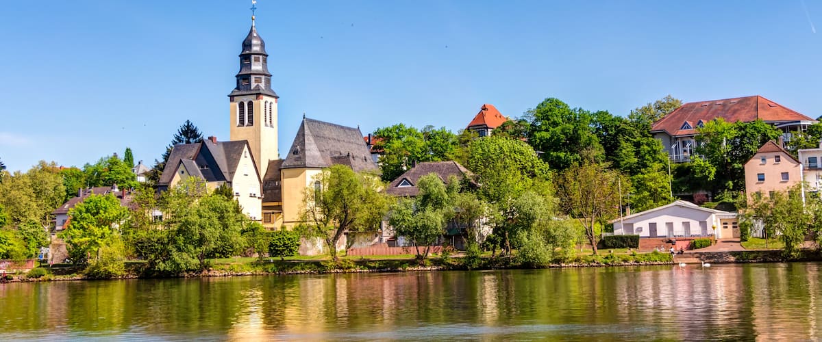A river with a church and residential buildings along the banks.