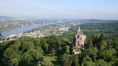A castle surrounded by lush greenery, a river, and a distant cityscape.