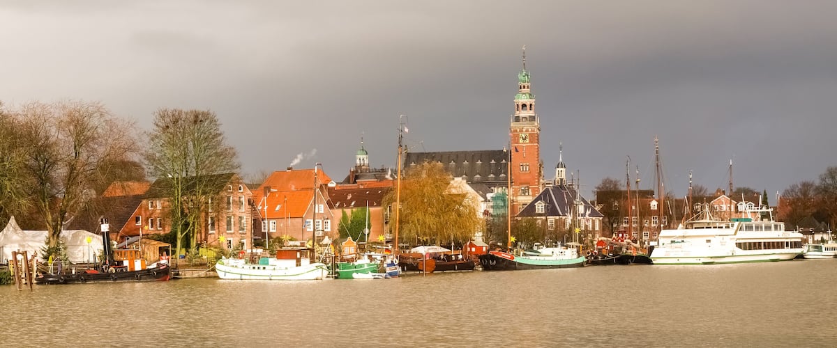 A river with boats, a prominent tower, and historic buildings along the banks.
