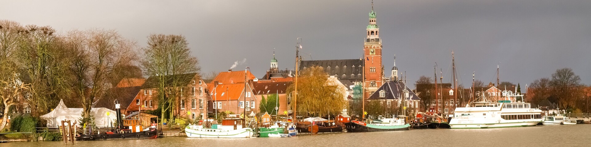 A river with boats, a prominent tower, and historic buildings along the banks.