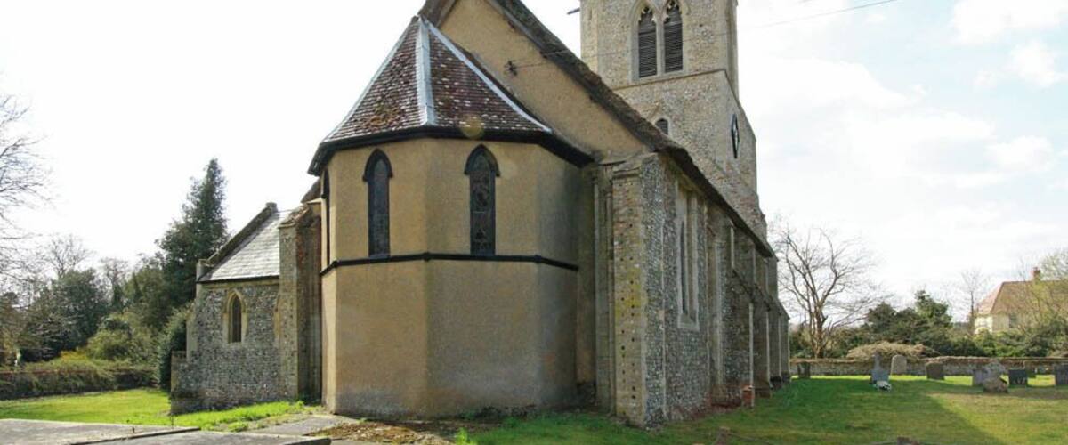 A church with a bell tower and a stone wall.