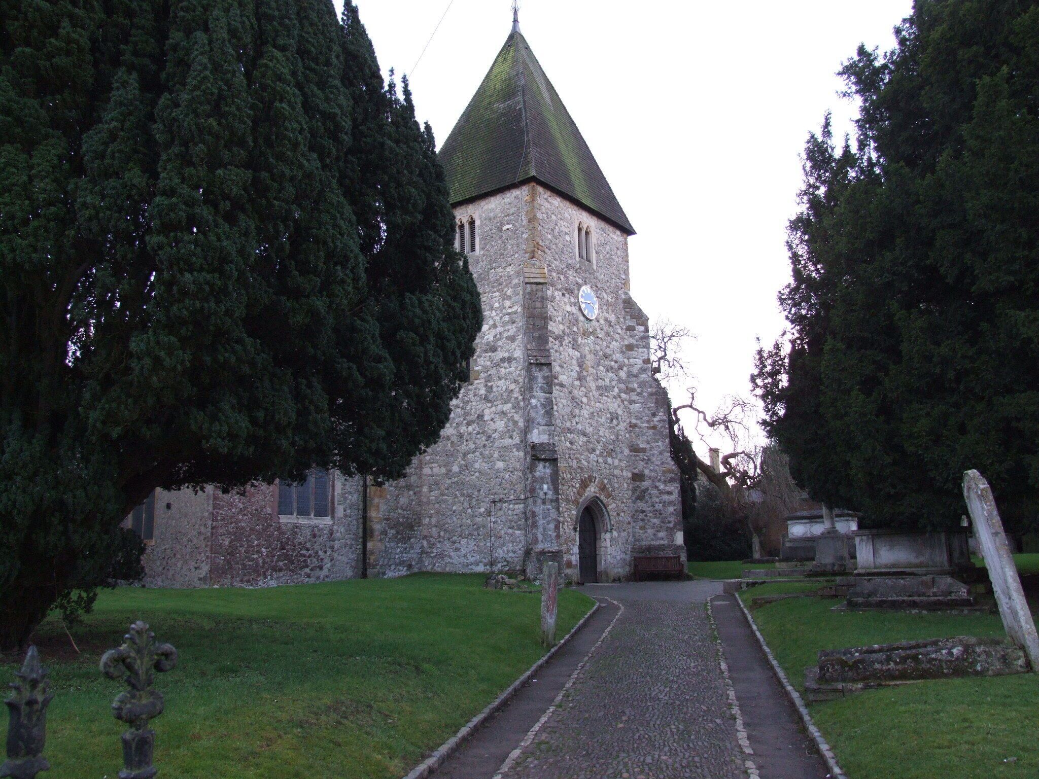 A stone church with a green roof and a clock on its tower.
