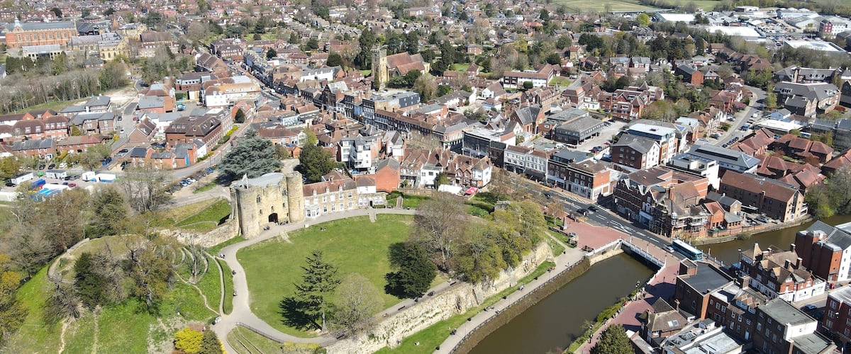 An aerial view of a town with a river, historic buildings, and a castle.