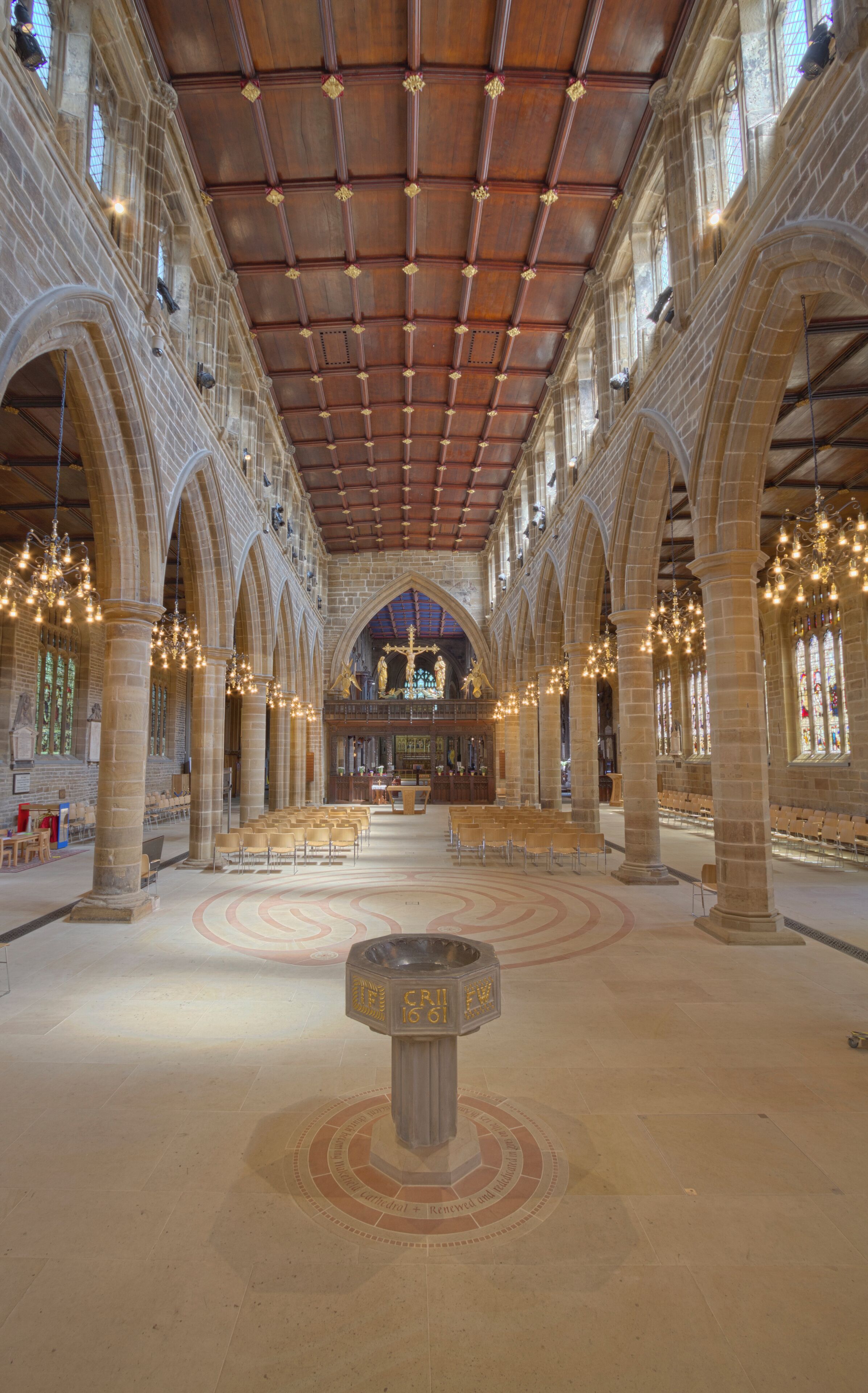 A cathedral interior with arched ceilings, stained glass windows, and a central altar.