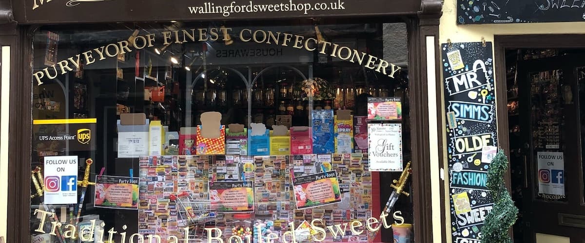 A storefront with a sign reading "Mr. Simms Olde Sweet Shoppe" and a window display of various sweets.