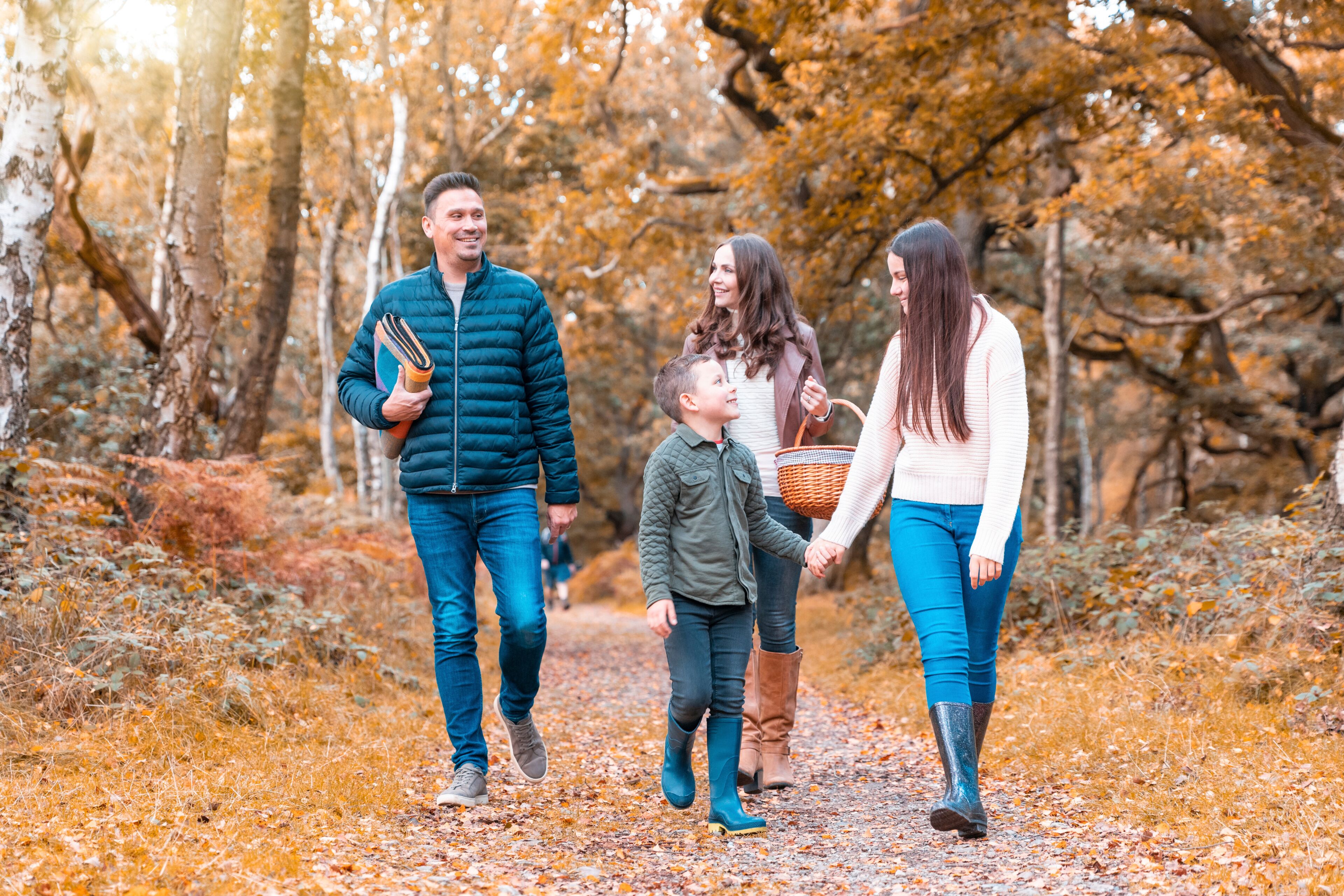 Happy family walking in Cannock Chase park during autumn