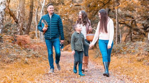 Happy family walking in Cannock Chase park during autumn