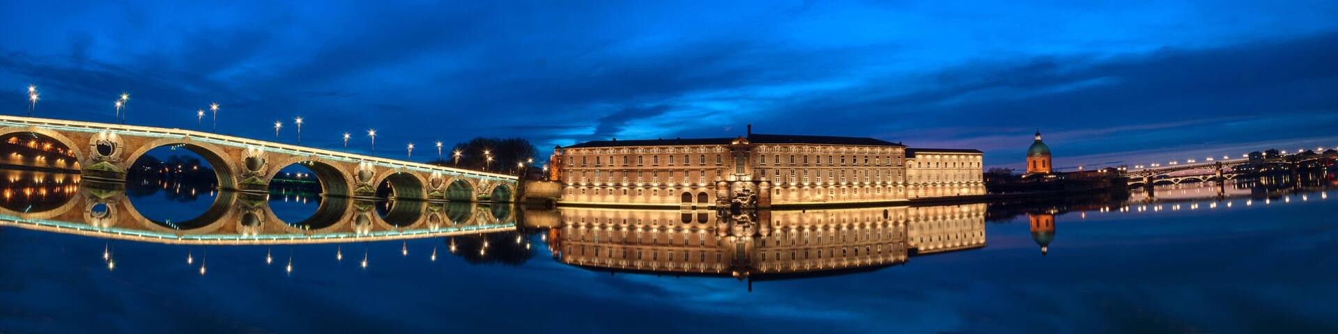 A panoramic view of the Pont Neuf bridge spanning the Garonne River in the heart of Toulouse, France