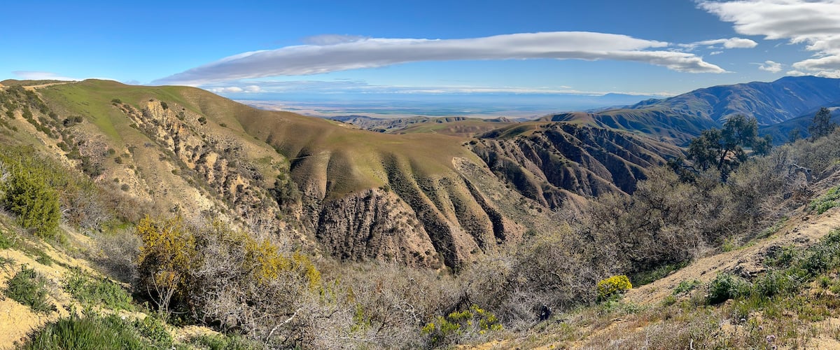 A mountainous landscape with rolling hills and sparse vegetation.