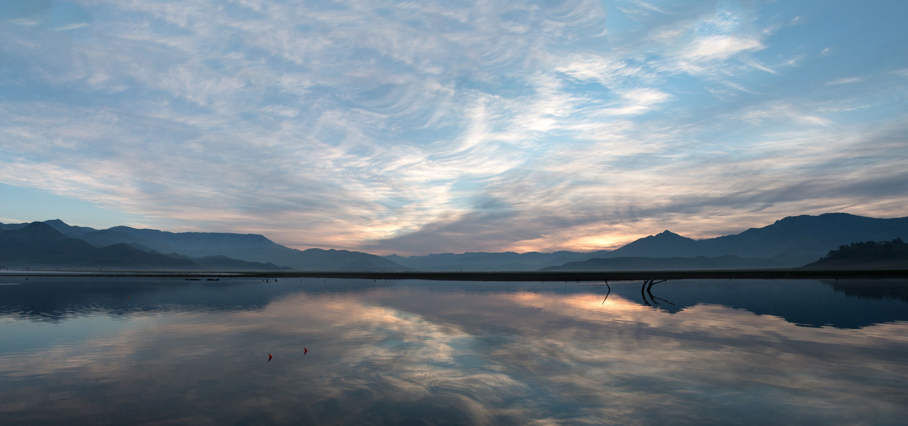 Sunrise cloudscape reflected in Lake Isabella in the southern Sierra Nevada mountains in California United States