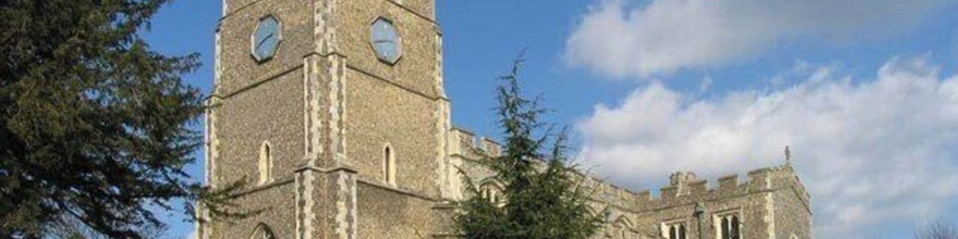 Una iglesia histórica con una torre alta y ventanas de arco.