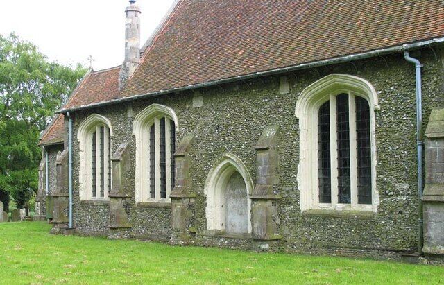 A stone church with arched windows and a tiled roof.