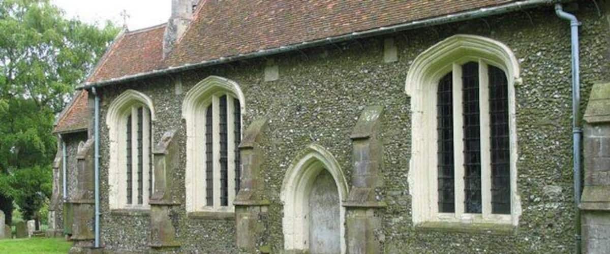 A stone church with arched windows and a tiled roof.