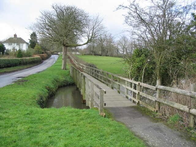 Watery Lane. Horningsham A view looking west along Watery lane showing the wooden footbridge over the millpond at Horningsham.
