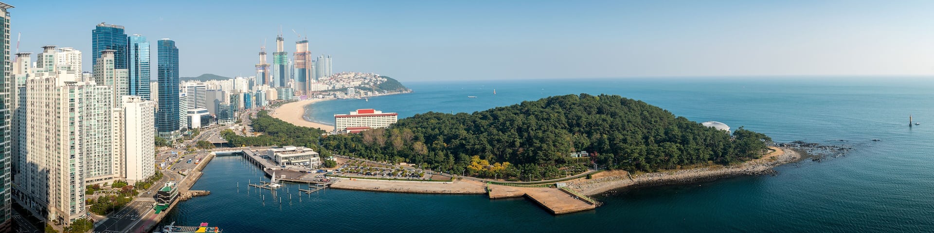Aerial view panorama of skyscrapers and Haeundae beach with beautiful sea in the summer of Busan, South Korea. Busan tourism, modern city life, or business finance and economy concept