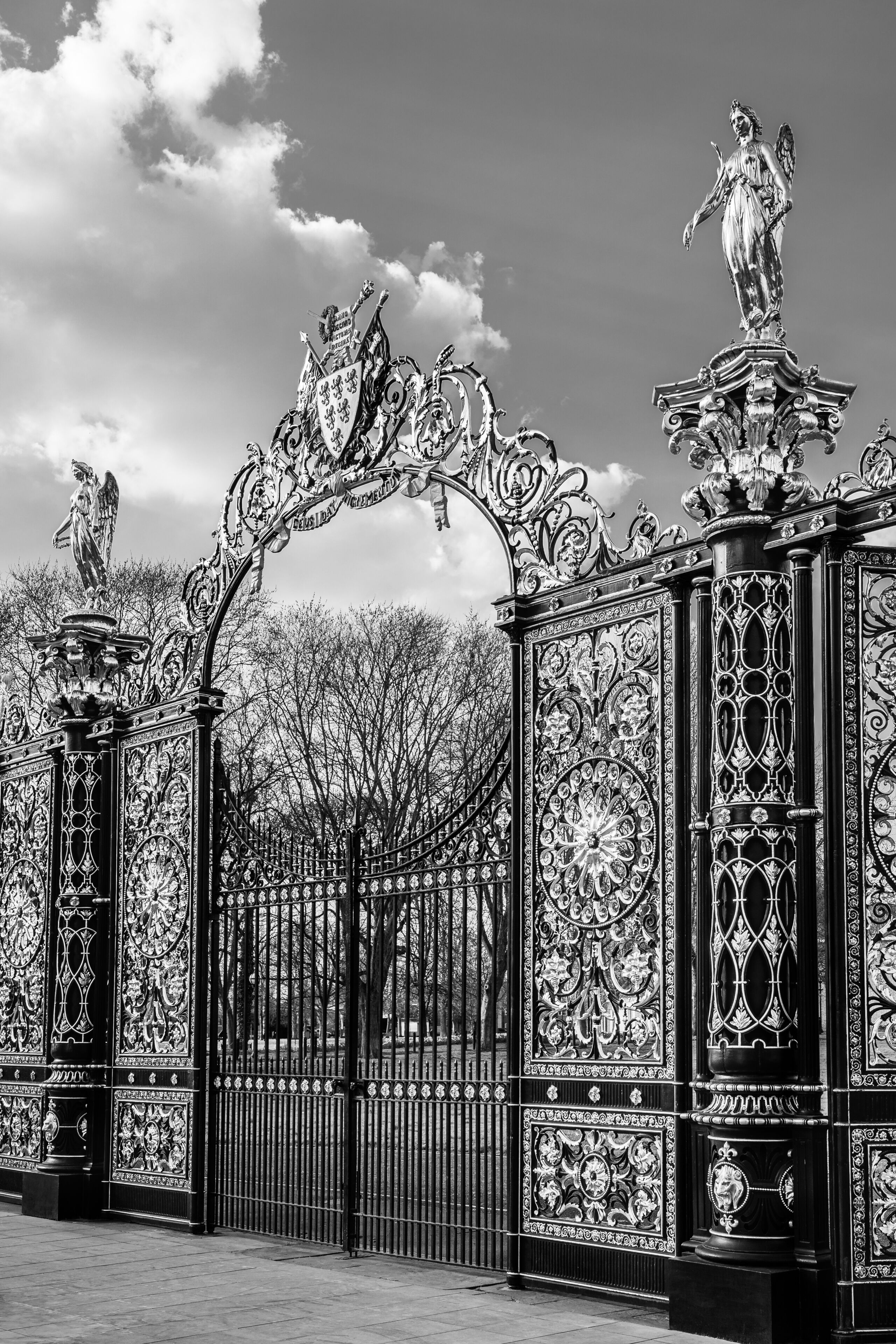 Um portão de ferro ornamentado com desenhos intrincados e estátuas.