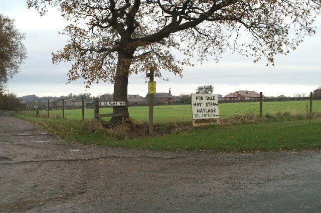 A rural landscape with a signboard advertising a property for sale.