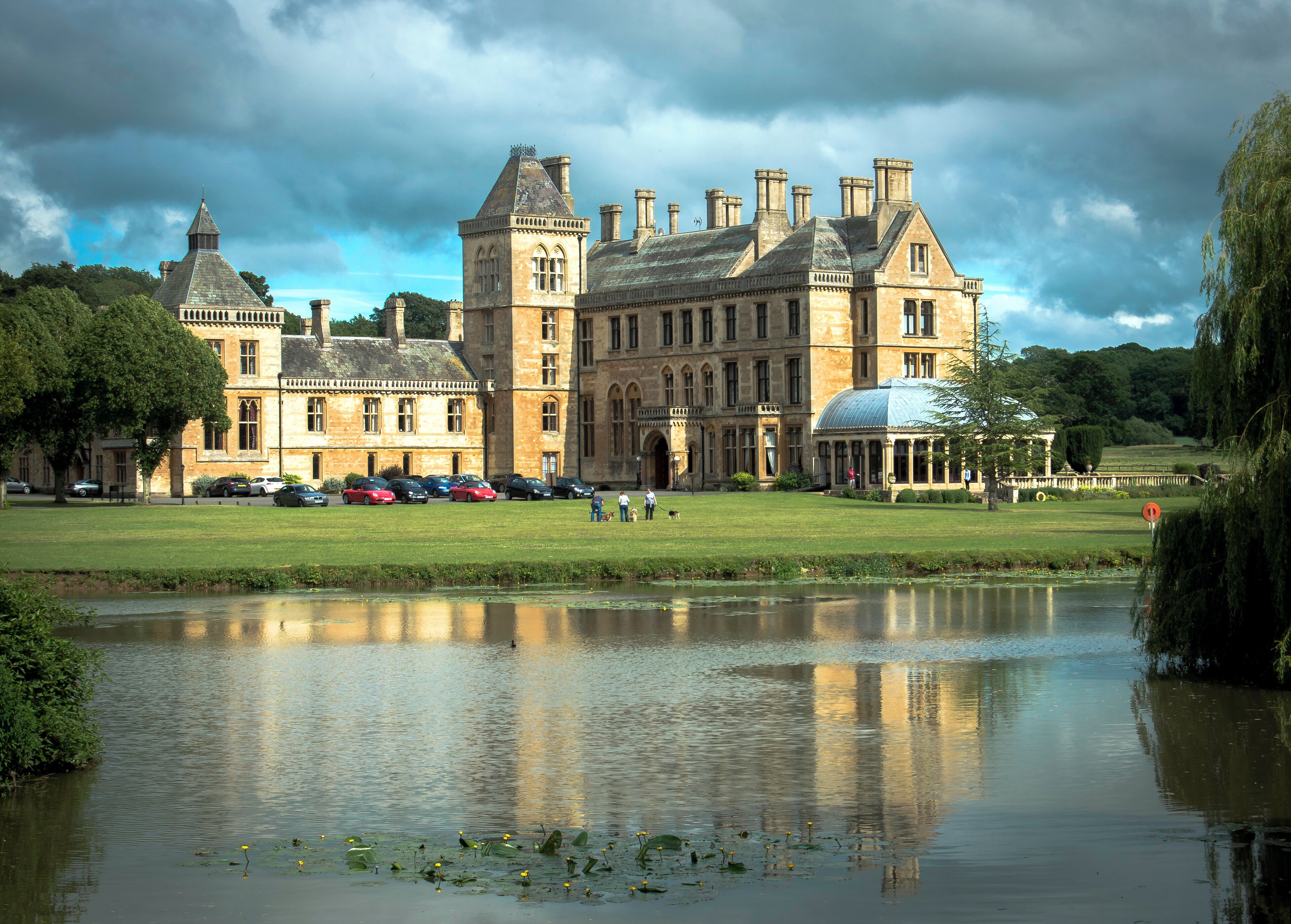 A historic building with a large lawn and a pond.