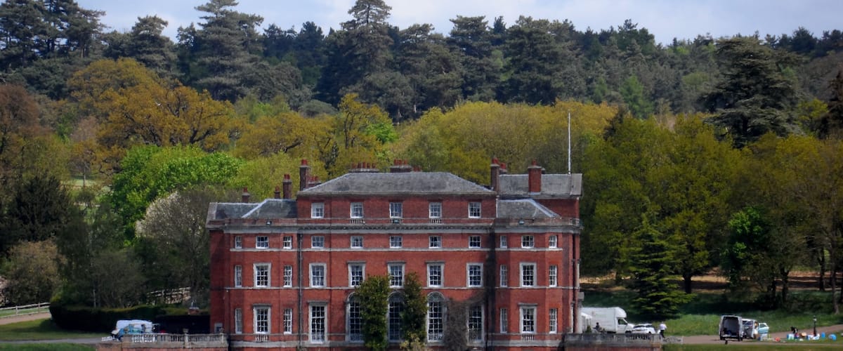 A large red brick building with a green lawn in front.