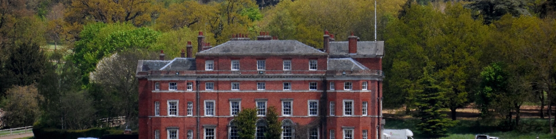 A large red brick building with a green lawn in front.