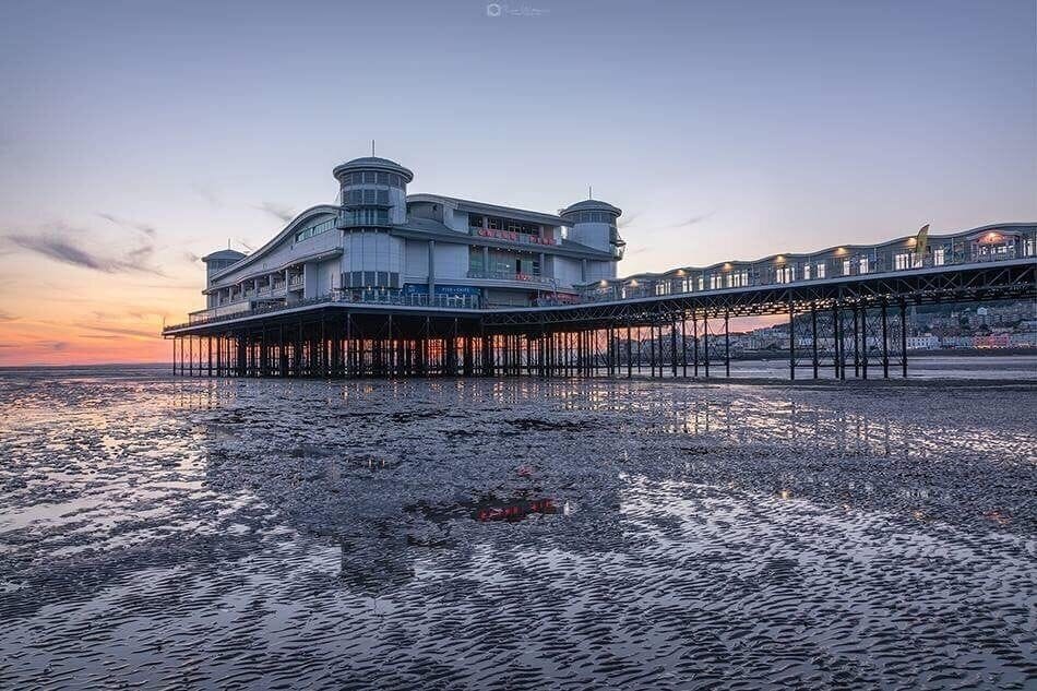 A waterfront building with a pier extending into the water.