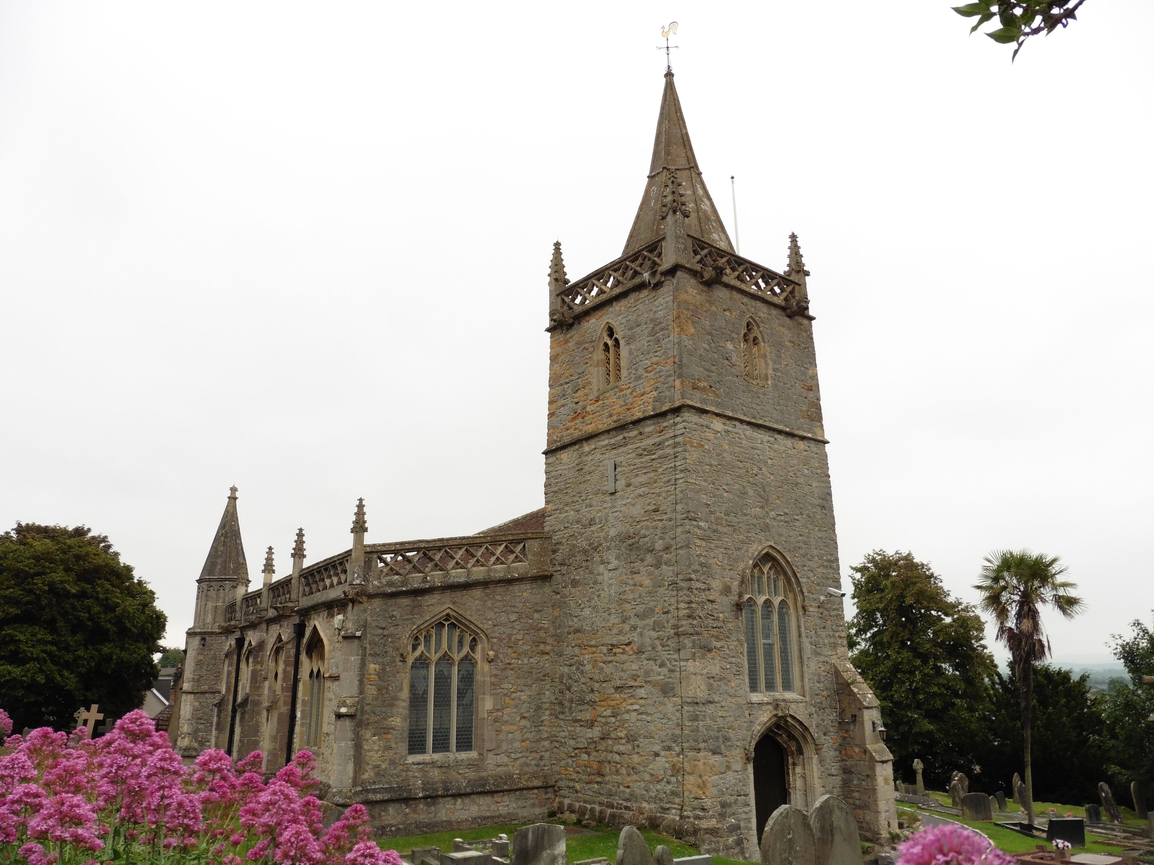 A historic stone church with a tall spire and arched windows.