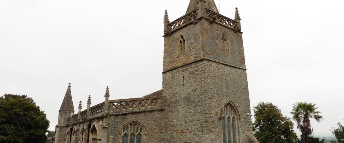 A historic stone church with a tall spire and arched windows.