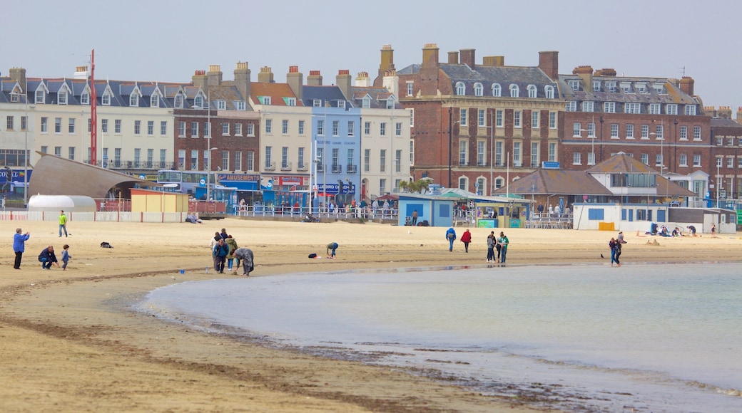 Weymouth mostrando una playa y arquitectura patrimonial y también un pequeño grupo de personas