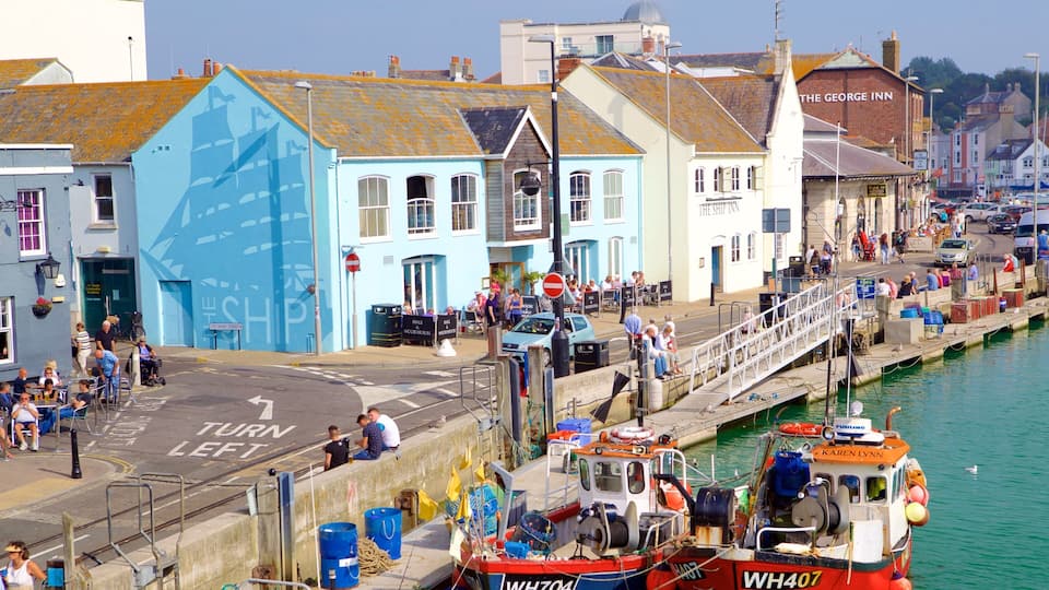 A coastal town with a narrow waterway, a bridge, and a row of colorful buildings.