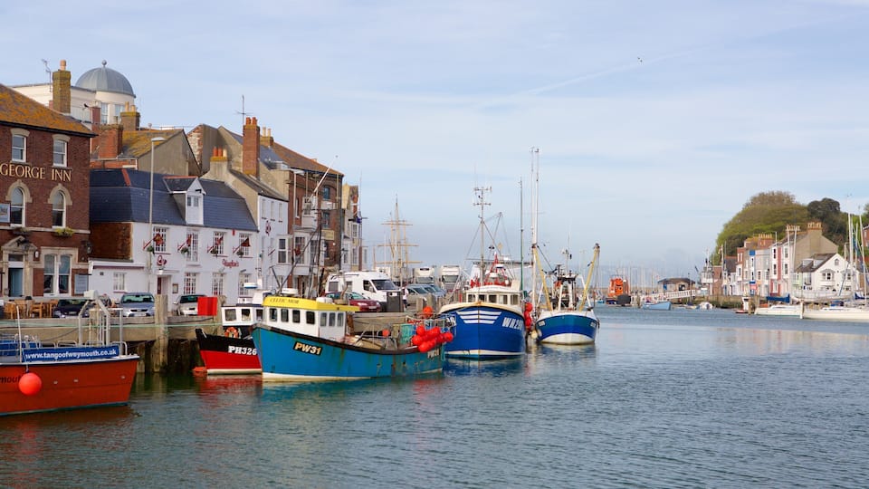 A harbor with boats docked, buildings along the waterfront, and a clear sky.