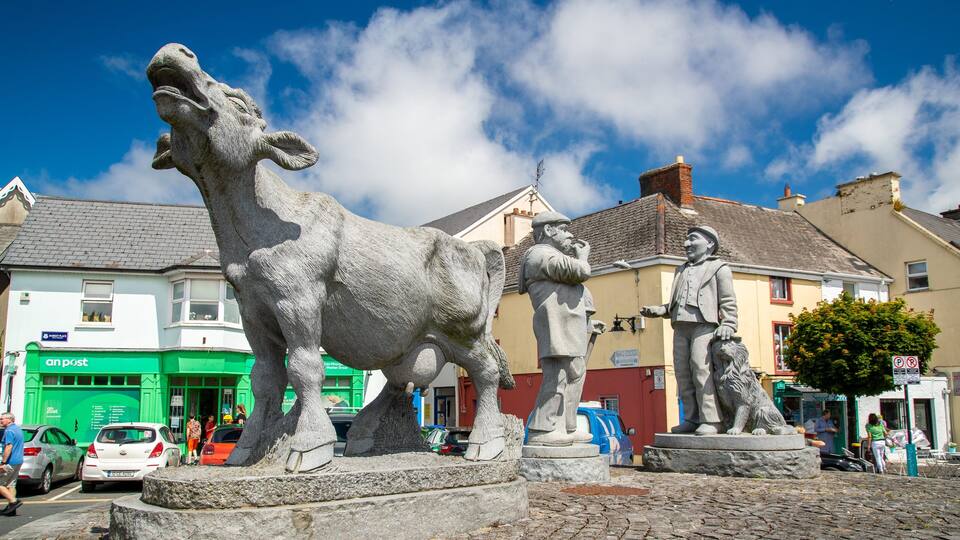 A statue of a man with a lion, a cow, and a horse in a town square.
