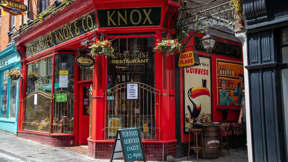 A red storefront with signs for Alexander Knox & Co. and Guinness.