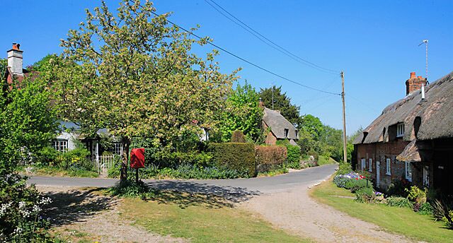 Housing in Dean Lane, Sparsholt The lane turns through 90 degrees here, which marks the start of a group of houses all by themselves in the middle of farm land.