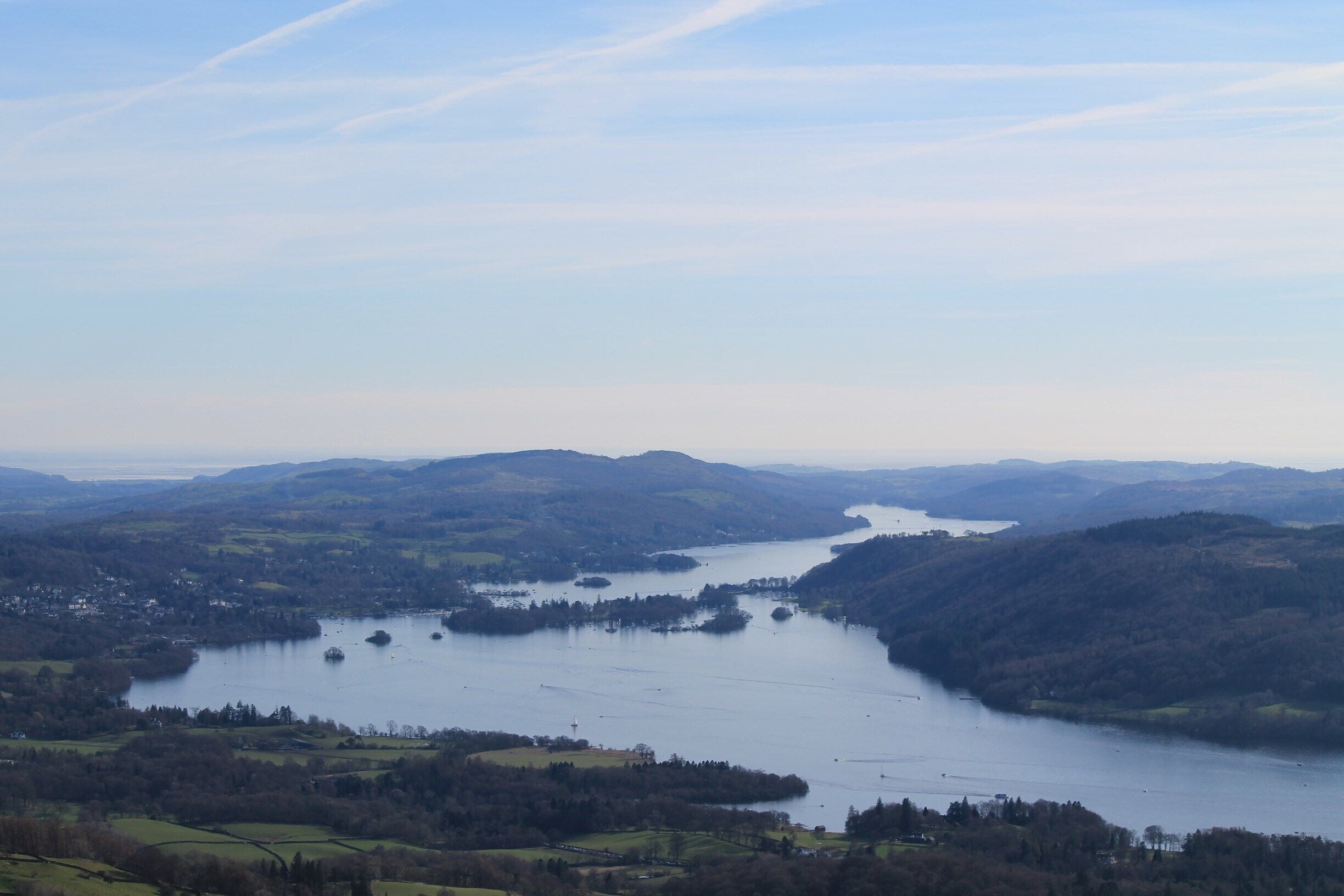 A river winding through a valley with hills on either side and a small town at the river's edge.