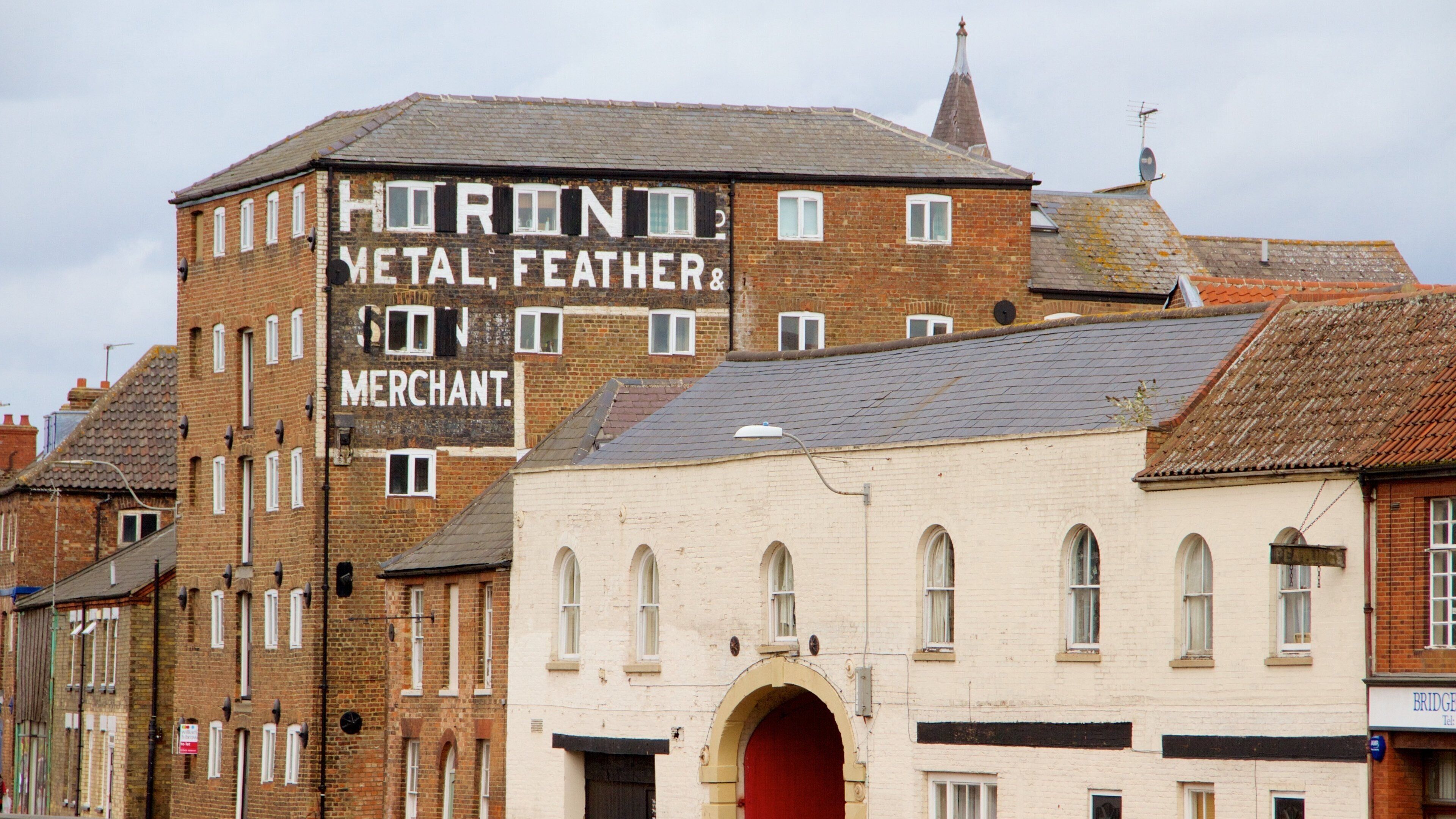 A building with a sign that reads "HORON METAL, FEATHER & MERCHANT."