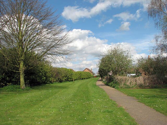 Wisbech & Upwell tramway - Upwell depot From the depot > 1241222 the tramway crossed Small Lode > 1241268 - heading northwards towards the village of Outwell. Nothing of the trackbed remains but its course can still be glimpsed at this short section of footpath. Wisbech & Upwell tramway's Upwell depot was 5 miles 72 chains distant from Wisbech. The line had eleven sidings, with two originally allocated for passenger traffic. During the fruit season the sidings could hold more than a hundred vans. The depot had a cattle dock, a depot office, a passenger waiting room, and a coal merchant's office and staithes. There was also an ash pit, and an old GER tender was used for a water tower until 1953 when it was removed. http://www.lner.info/co/GER/wisbech/route.shtml When during the 13th century the estuary silted up, the fens surrounding the market town and port of Wisbech were reclaimed for agricultural use. The new agricultural prosperity soon attracted railways such as the Eastern Counties Railway which opened a branch in 1847. In 1848 the East Anglian Railway built a branch from Watlington. A third line was built by the Peterborough, Wisbech & Sutton Bridge Railway (later the Midland & Great Northern Joint Railway) which opened a station on the other side of the River Nene in 1866. The trains carried fruit and vegetables to markets as far afield as London. In addition, the construction of a tramway line connecting the villages Upwell and Outwell with Wisbech commenced in 1882. Board of Trade's tram restrictions resulted in the unusual-looking locomotives which not only had speed restrictions but controls at both ends and wooden cowcatchers and skirts over the wheels. Six trams a day in each direction provided passenger services, with the full one way journey taking one hour. By October 1884 traffic had grown to 3000 passengers per week, with peaks of 2000 in a day for fetes and other special events. The tram competed with a canal that ran between Wisbech and Upwell and with the canal being in a poor financial condition the tram eventually finished it off. When motor omnibuses started to appear, however, passenger numbers declined drastically and passenger services were withdrawn in 1927, whereas freight traffic continued to flourish. With the introduction of two Drewry Shunters (BR Class 04) in 1952, Wisbech & Upwell became Britain's first all-diesel line. The line closed in March 1966. http://www.lner.info/co/GER/wisbech/history.shtml