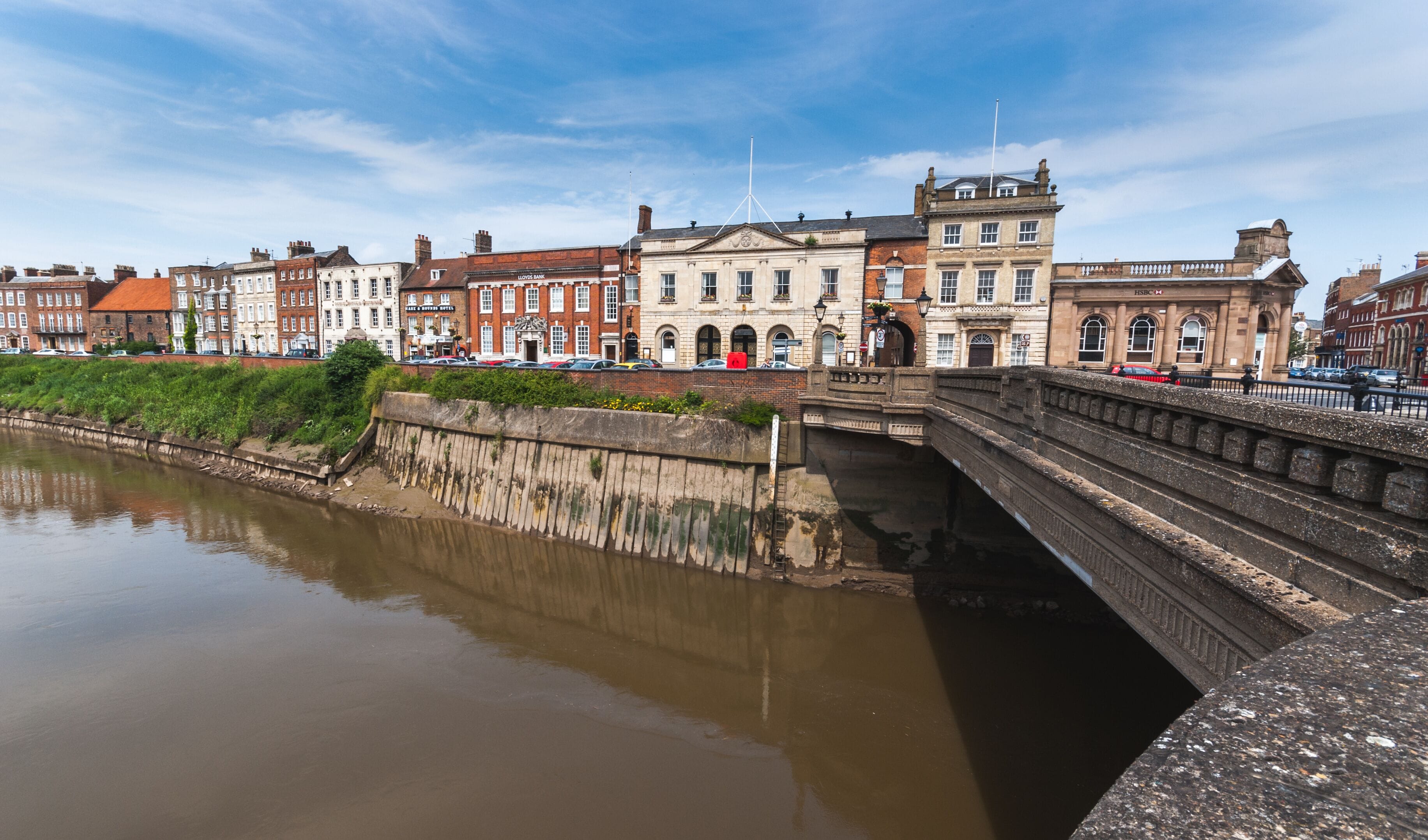 Un río con un puente y edificios históricos al fondo.